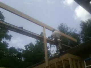 Carpenter setting a ridge beam over a new addition frame — Ice Dam Removal by Roofing Brothers in Rodessa