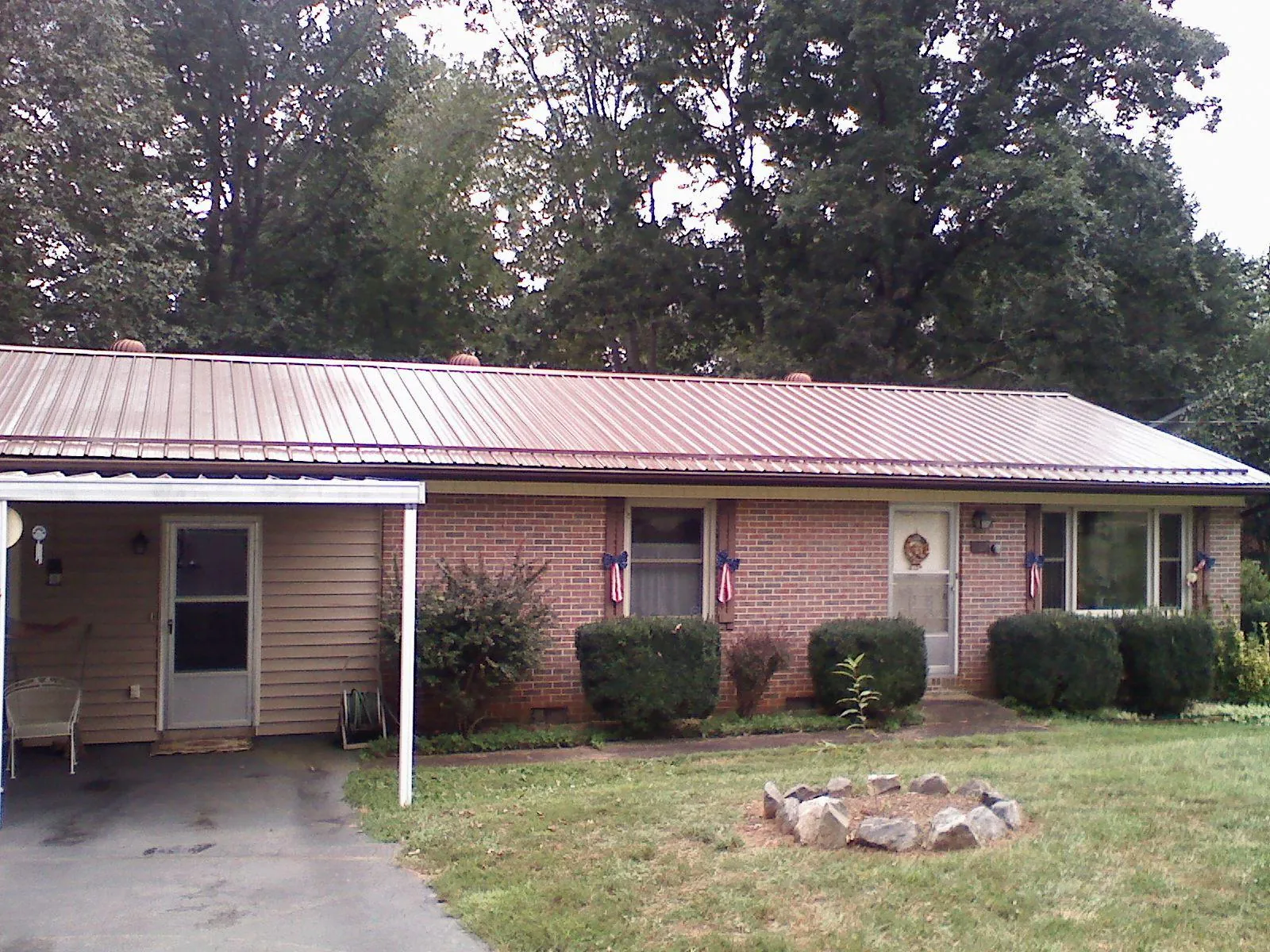 Bronze metal roof and carport on a brick ranch home — Roof Repair work by our crew in Rodessa